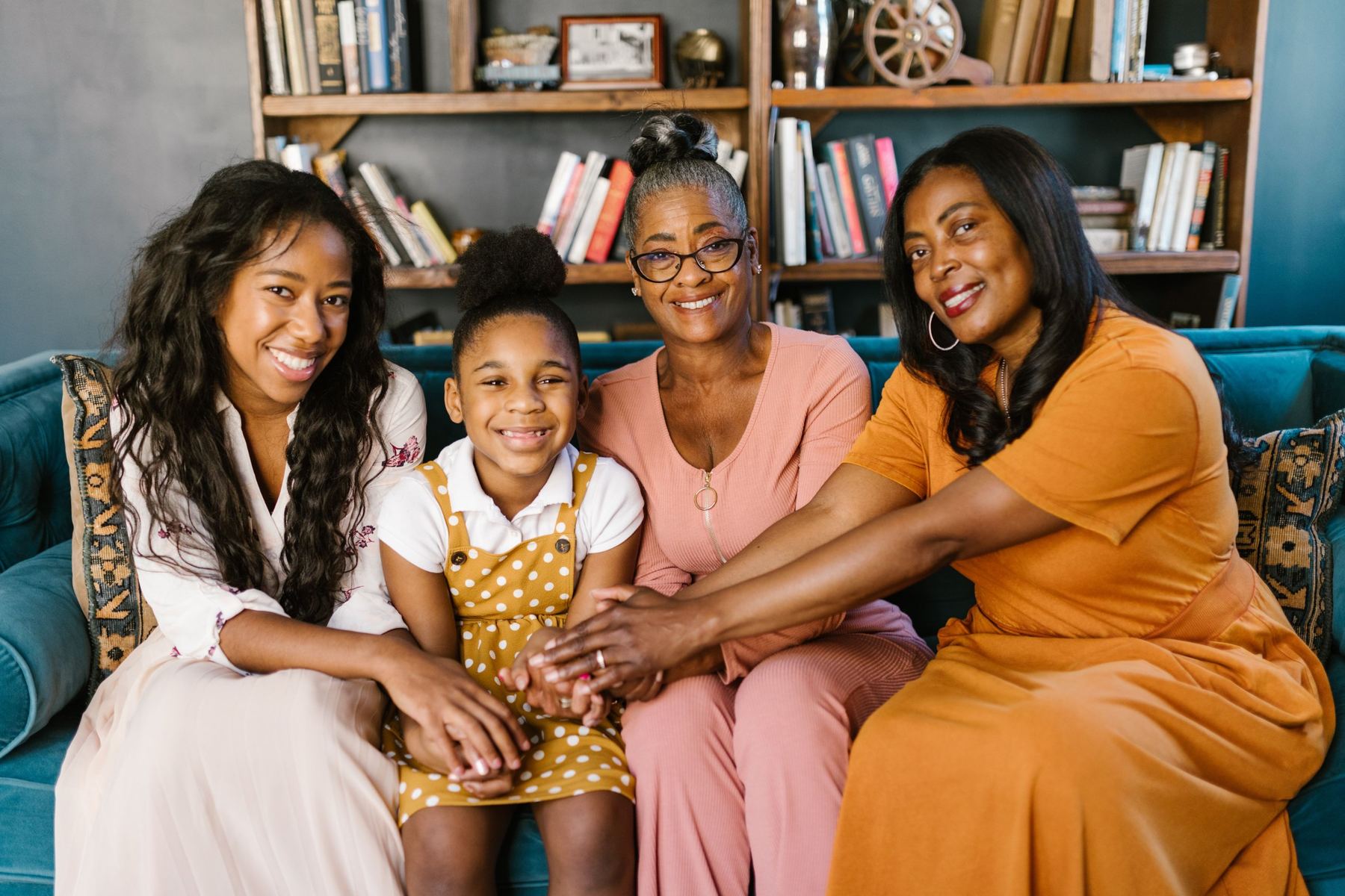 Four women from three generations of one family sitting together on a sofa