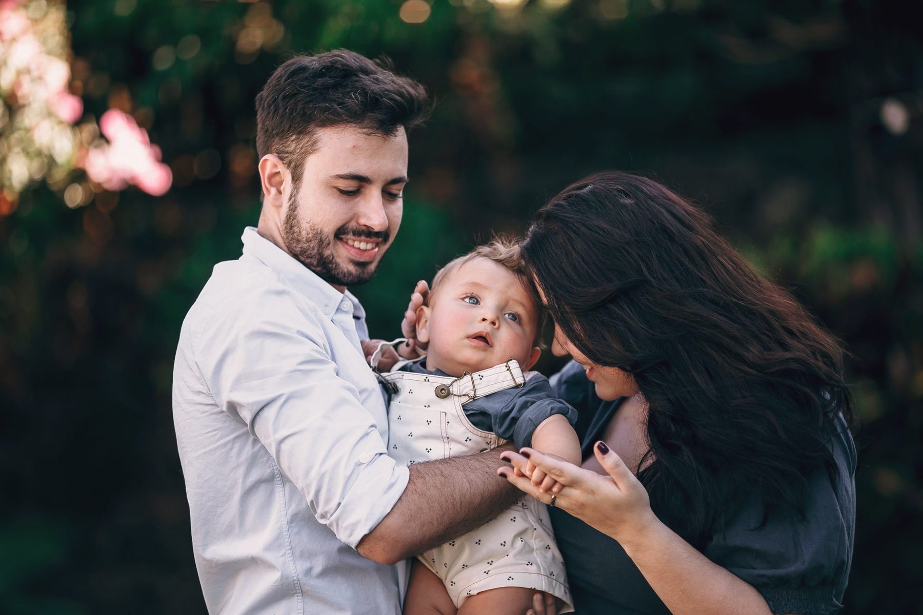 Young parents holding their baby outdoors at dusk