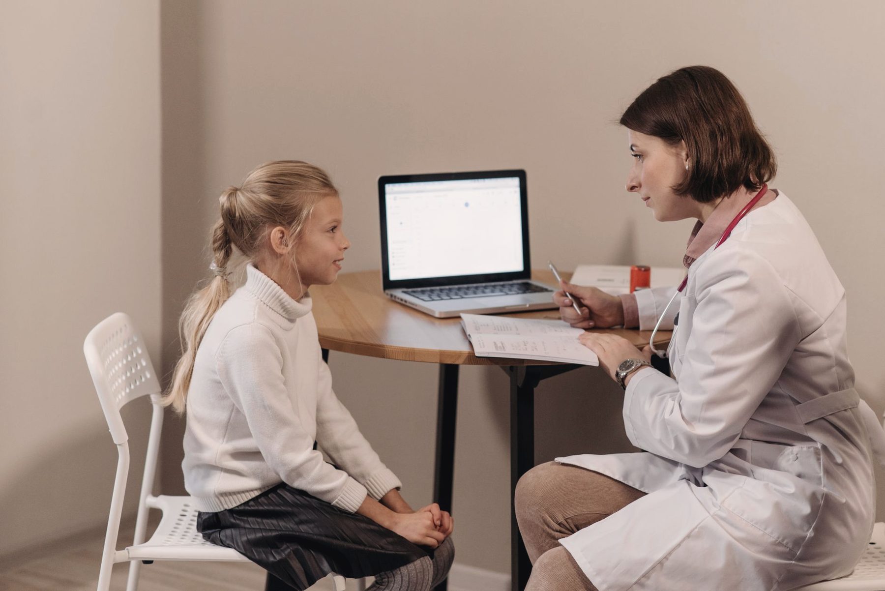 A doctor speaking with a young girl during a checkup