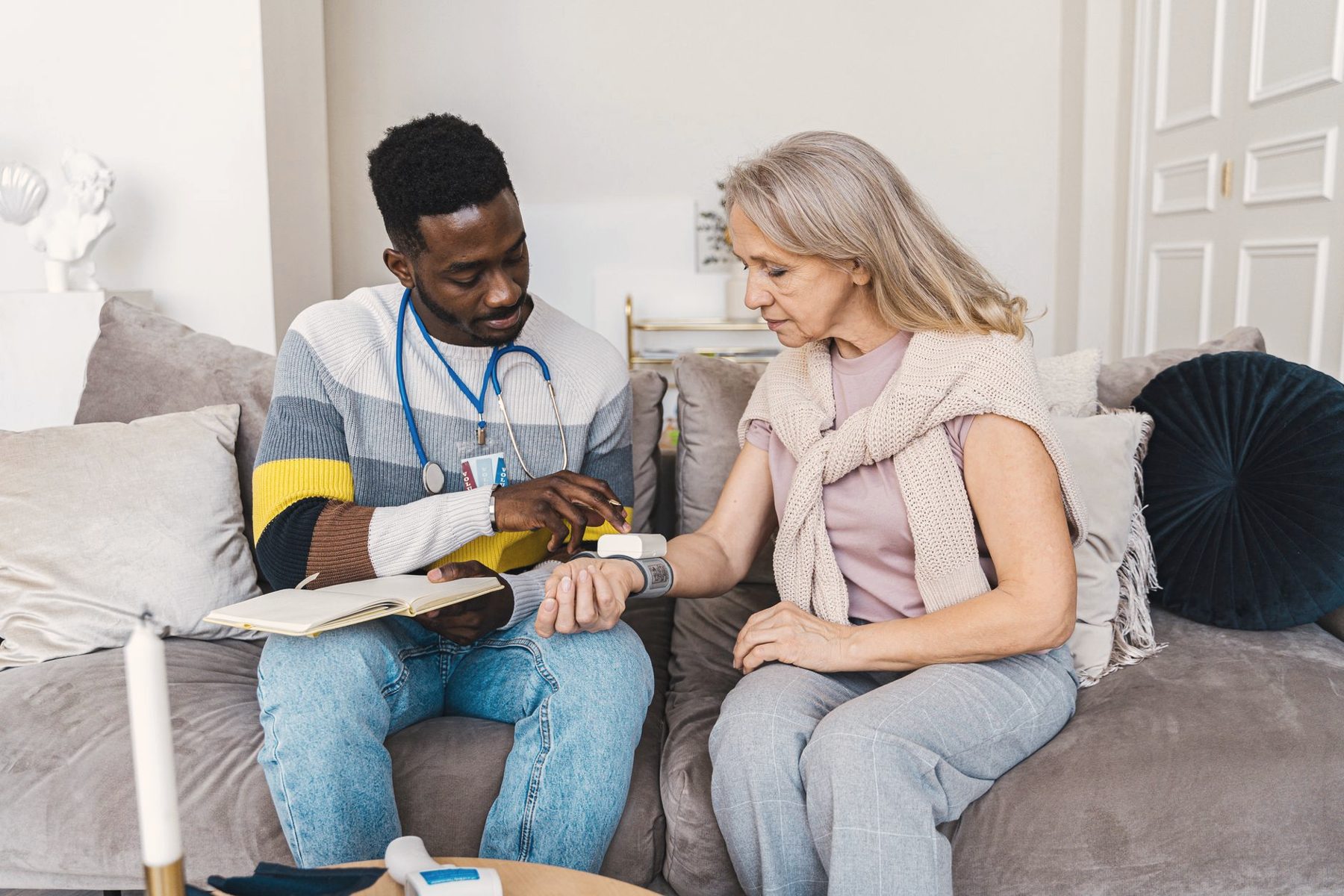 A caregiver checking in with an older woman in her living room