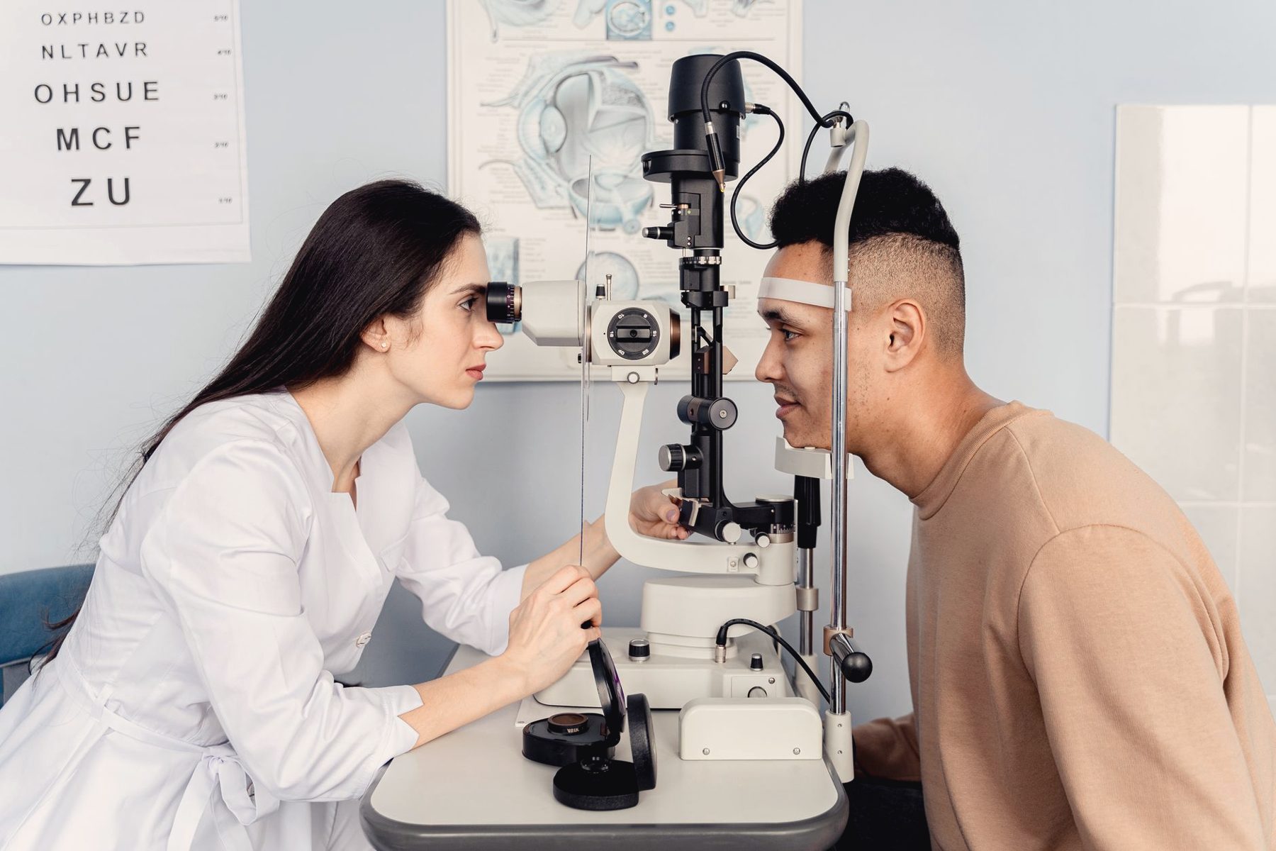 An optometrist examining a patient's eyes with a slit lamp